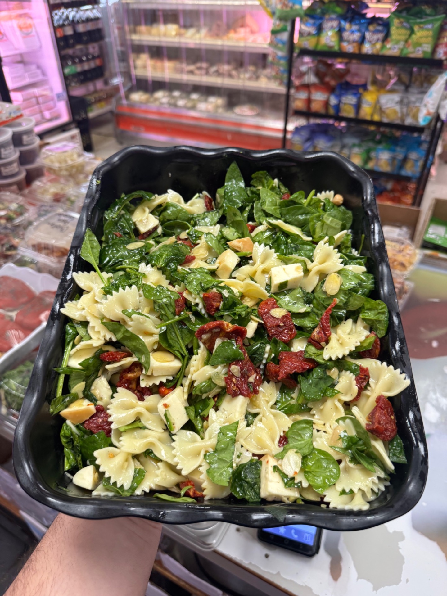 Bow-tie pasta salad with spinach, fresh mozzarella and sun-dried tomatoes