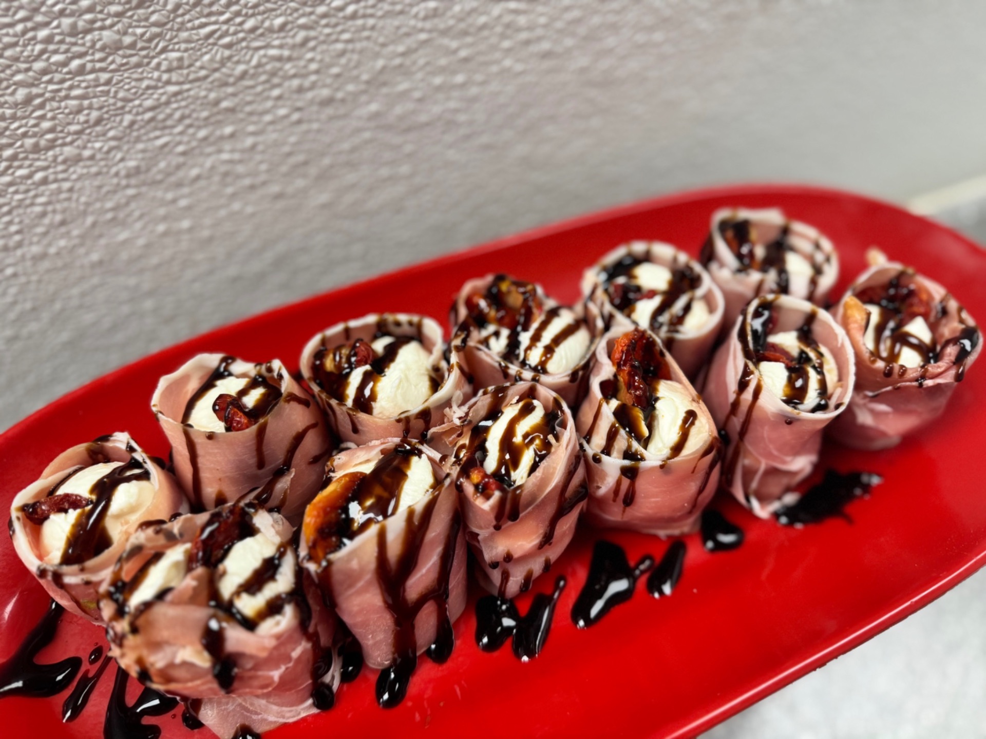 Prosciutto and fresh mozzarella roll-ups with balsamic glaze