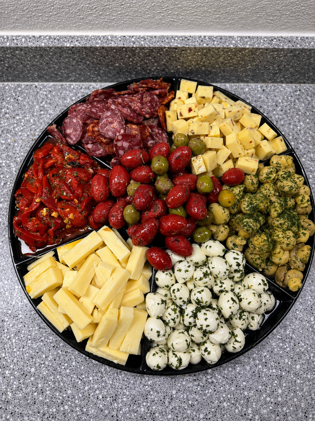 Italian antipasto platter with cured meats, cheeses, olives and marinated vegetables